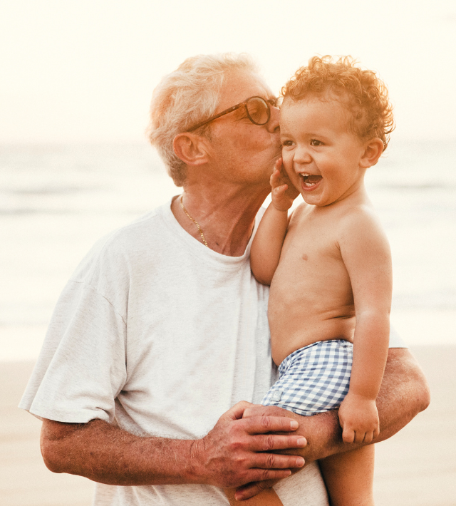 A grandfather and his young grandchild on the beach