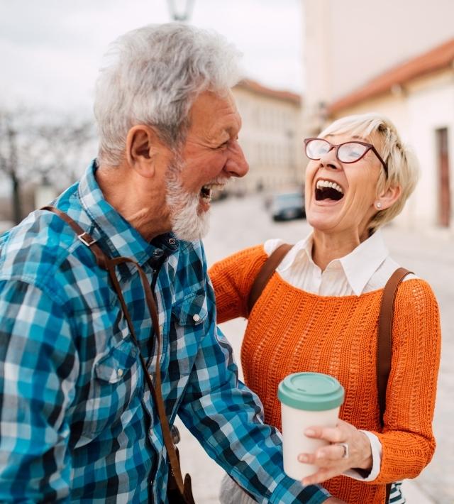 A senior couple outside laughing together