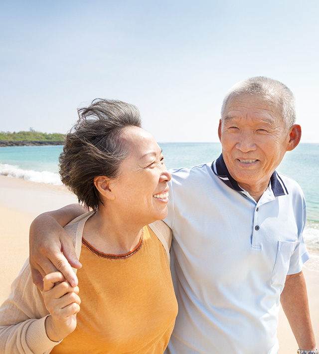 A senior couple walking on the beach
