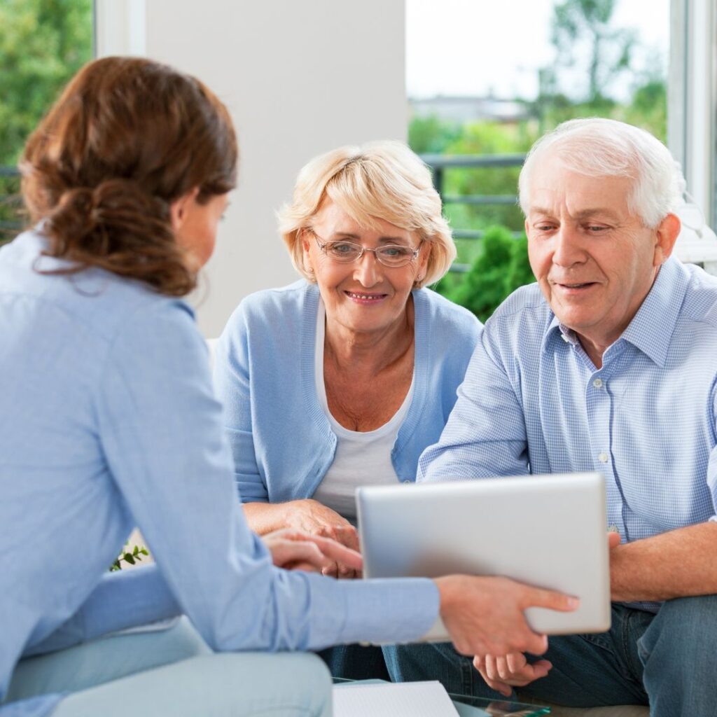 Senior couple looking at a tablet presented by their broker