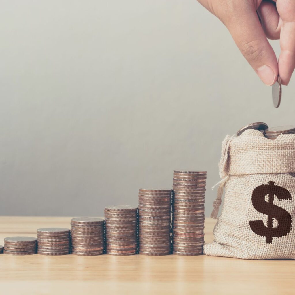 stacks of coins leading to a bag of money