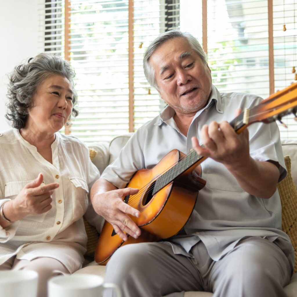 An older couple playing guitar