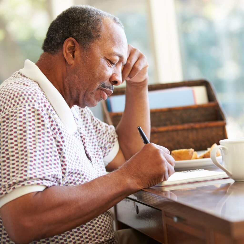 senior man writing on notepad