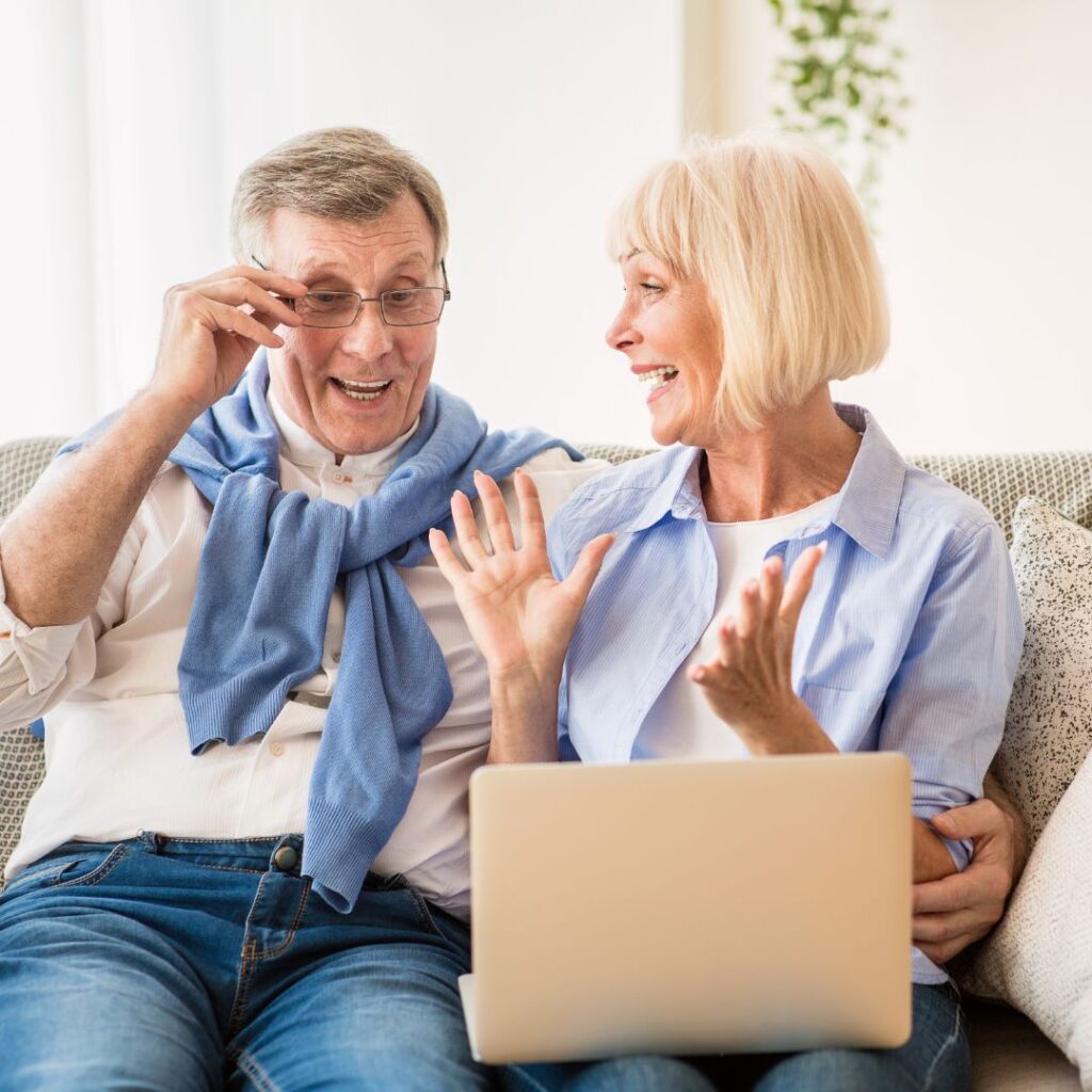 senior couple smiling at computer
