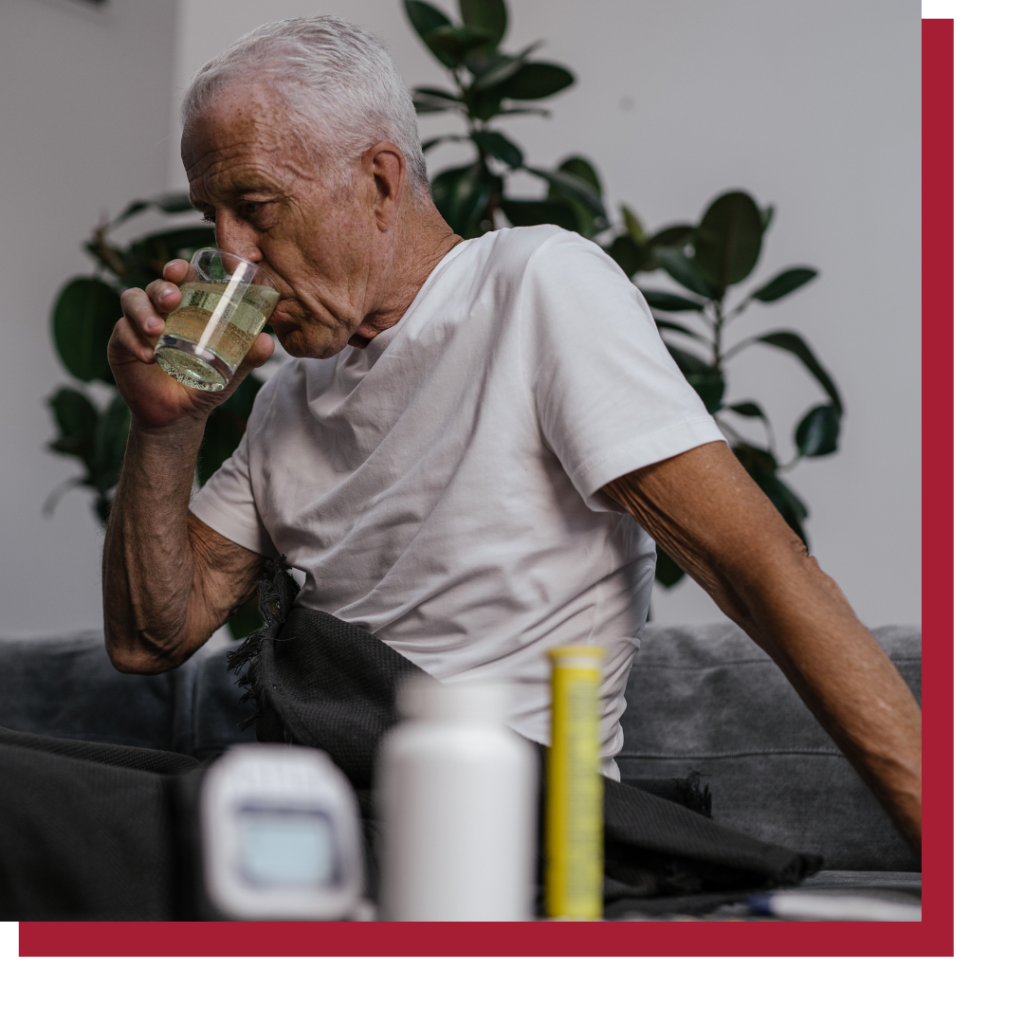 an elderly man taking pills