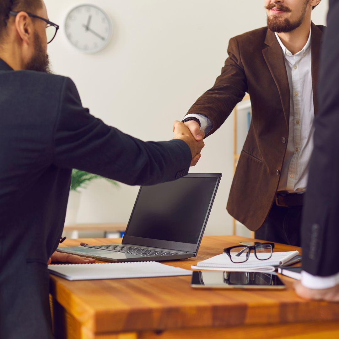 Two men in business attire shaking hands