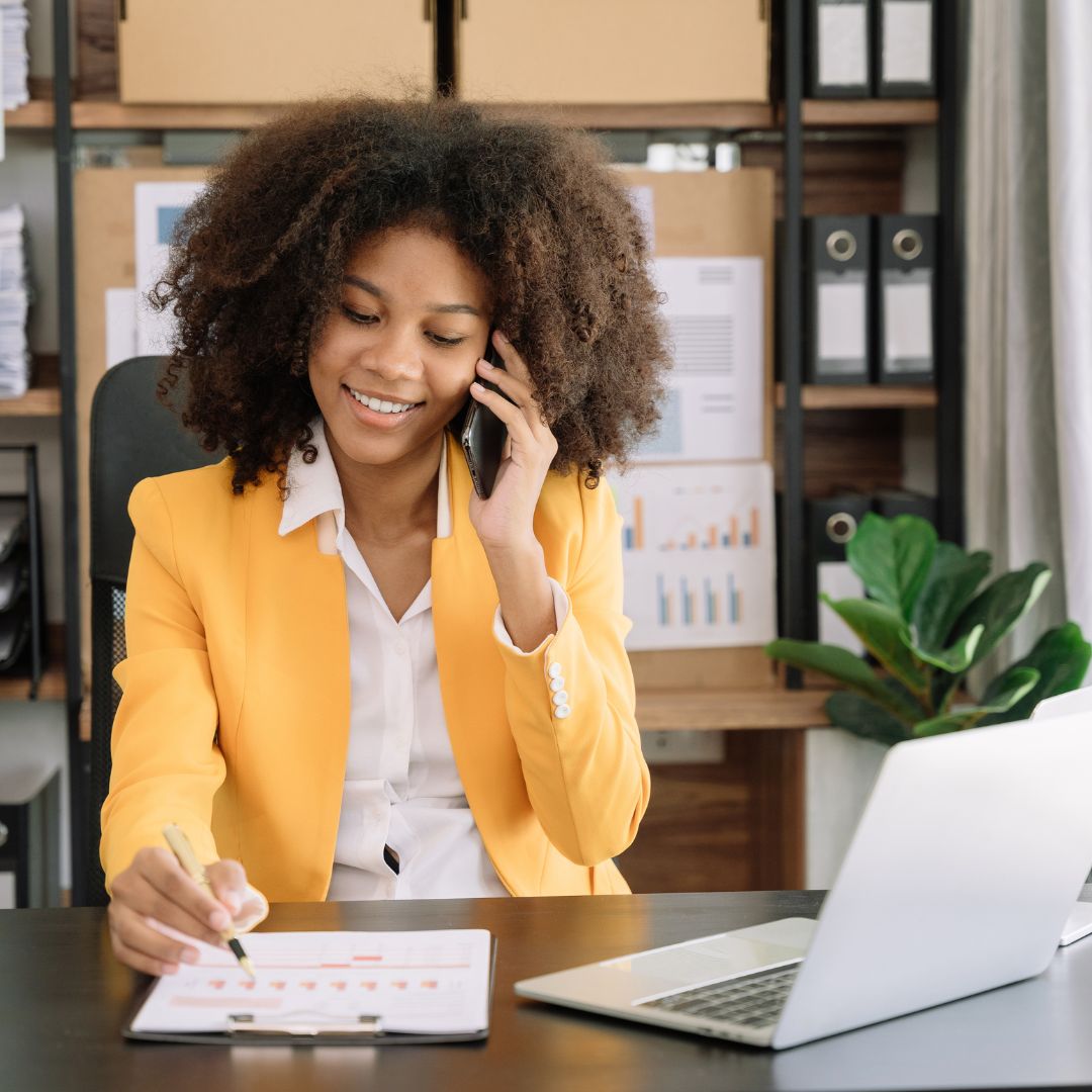 woman taking a phone call with a laptop