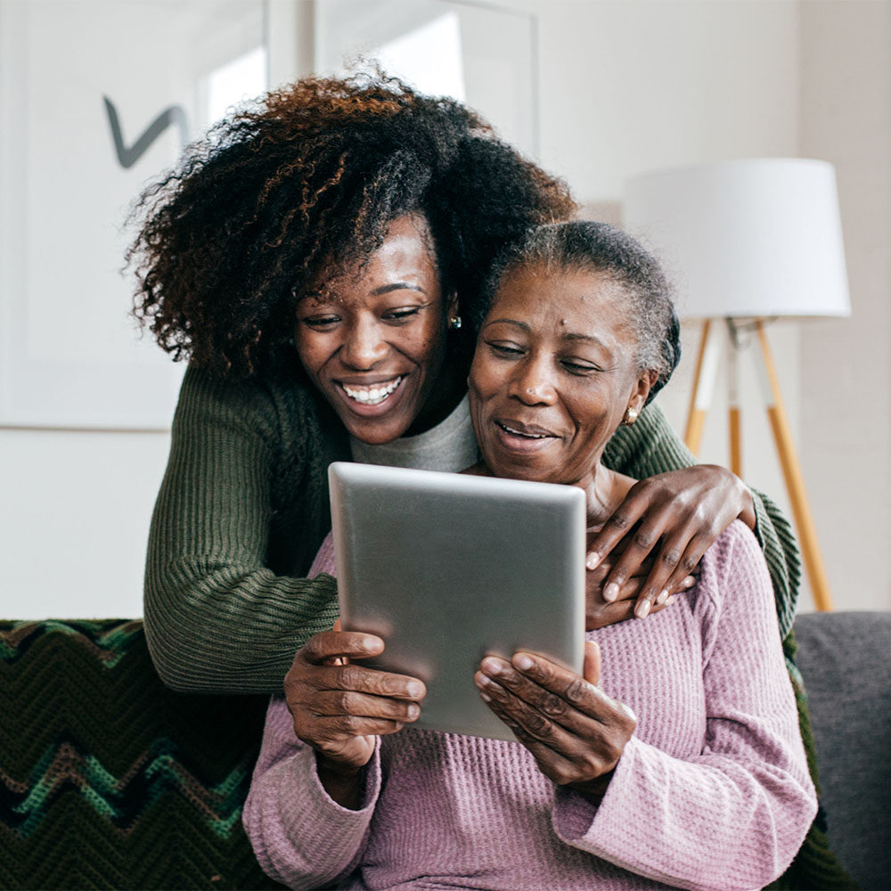 senior with daughter looking at tablet